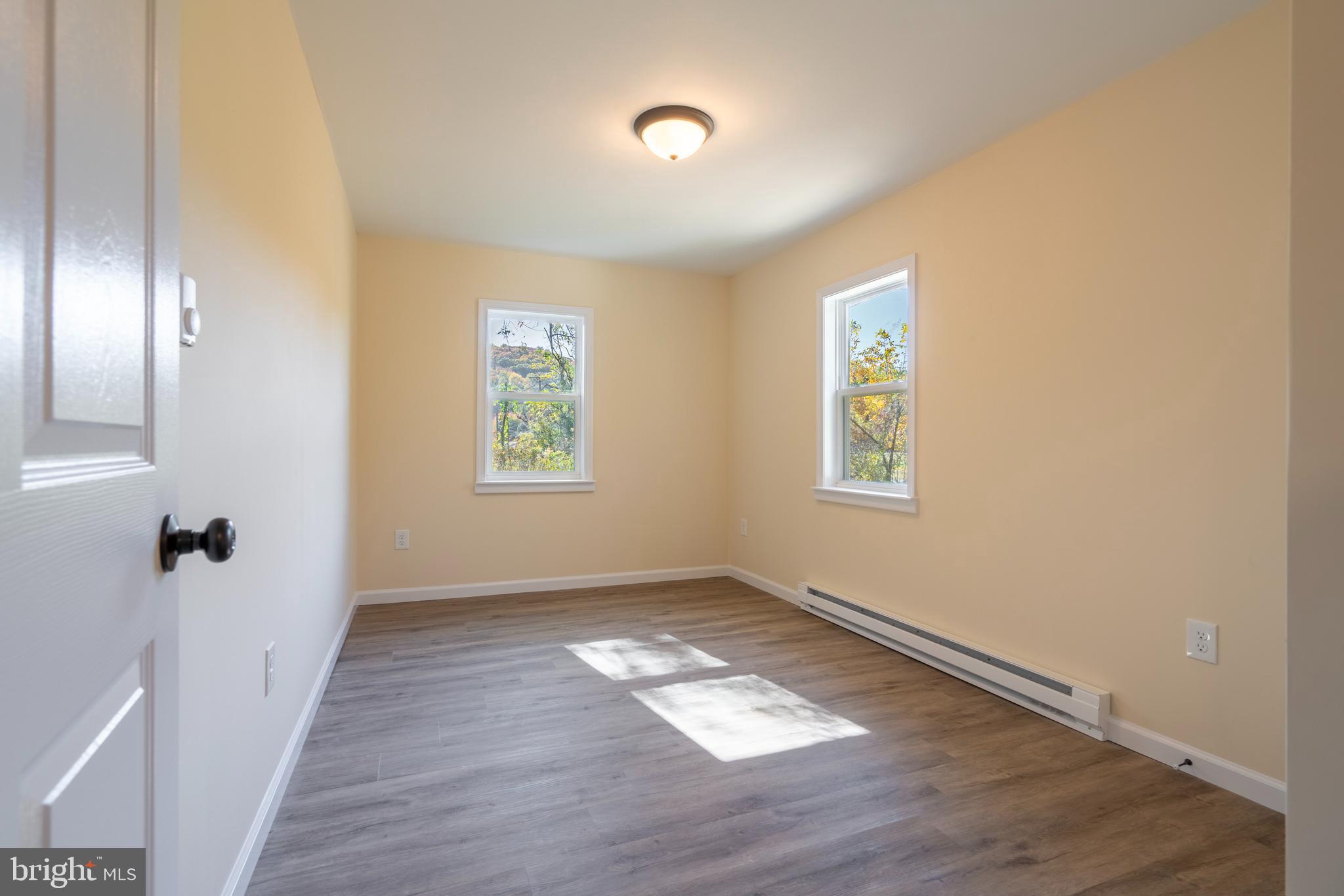 201 Hill Church Road Bechtelsville, PA 19505 - Photo 10 of 28 an empty room with wooden floor and windows