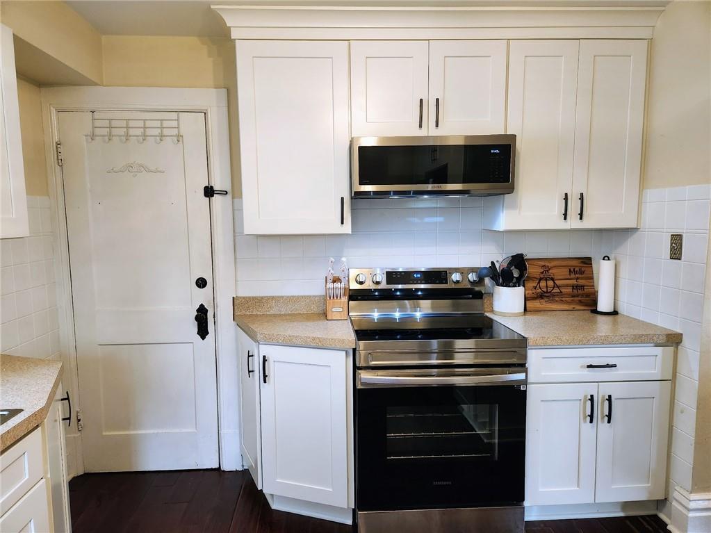 614 3rd Street Butler, PA 16001 - Photo 9 of 43 a kitchen with stainless steel appliances granite countertop a stove a microwave and a white cabinets