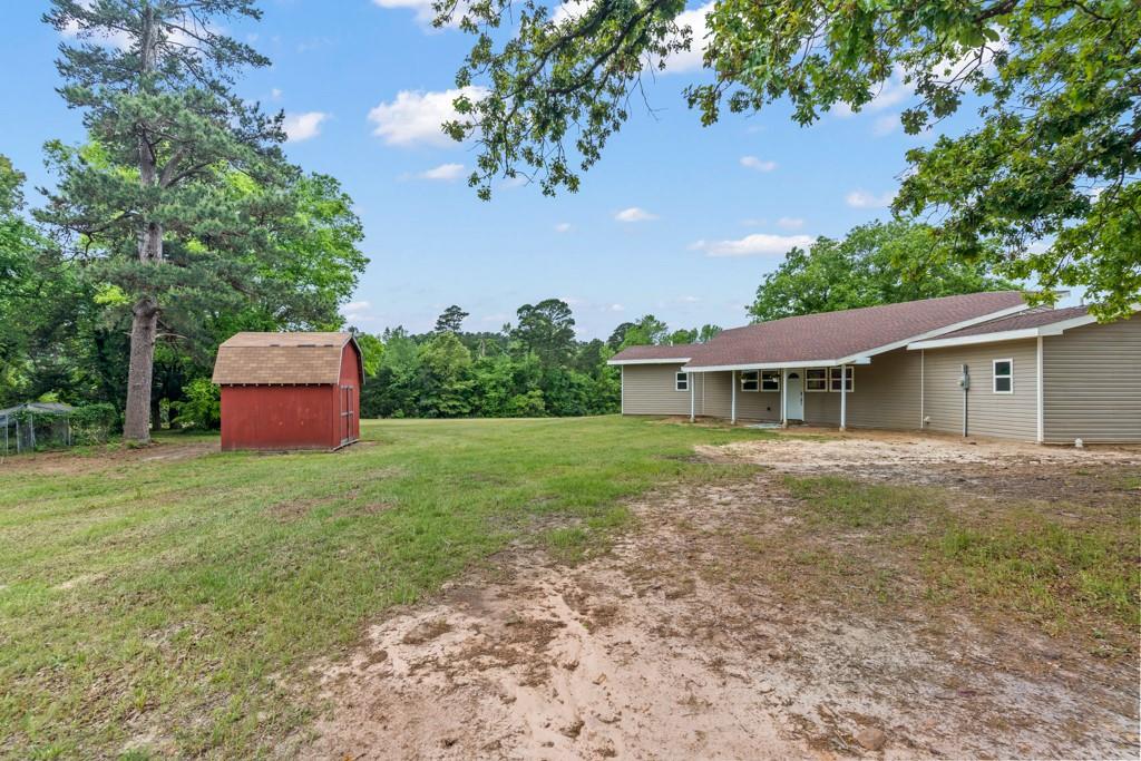 1129 Holly Road Gilmer, TX 75644 - Photo 30 of 31 Expansive green lawn and red storage shed