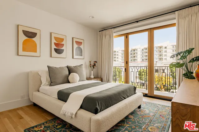 a bedroom with bed and a large window