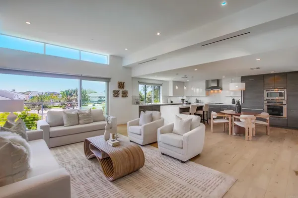 a living room with furniture wooden floor and a large window