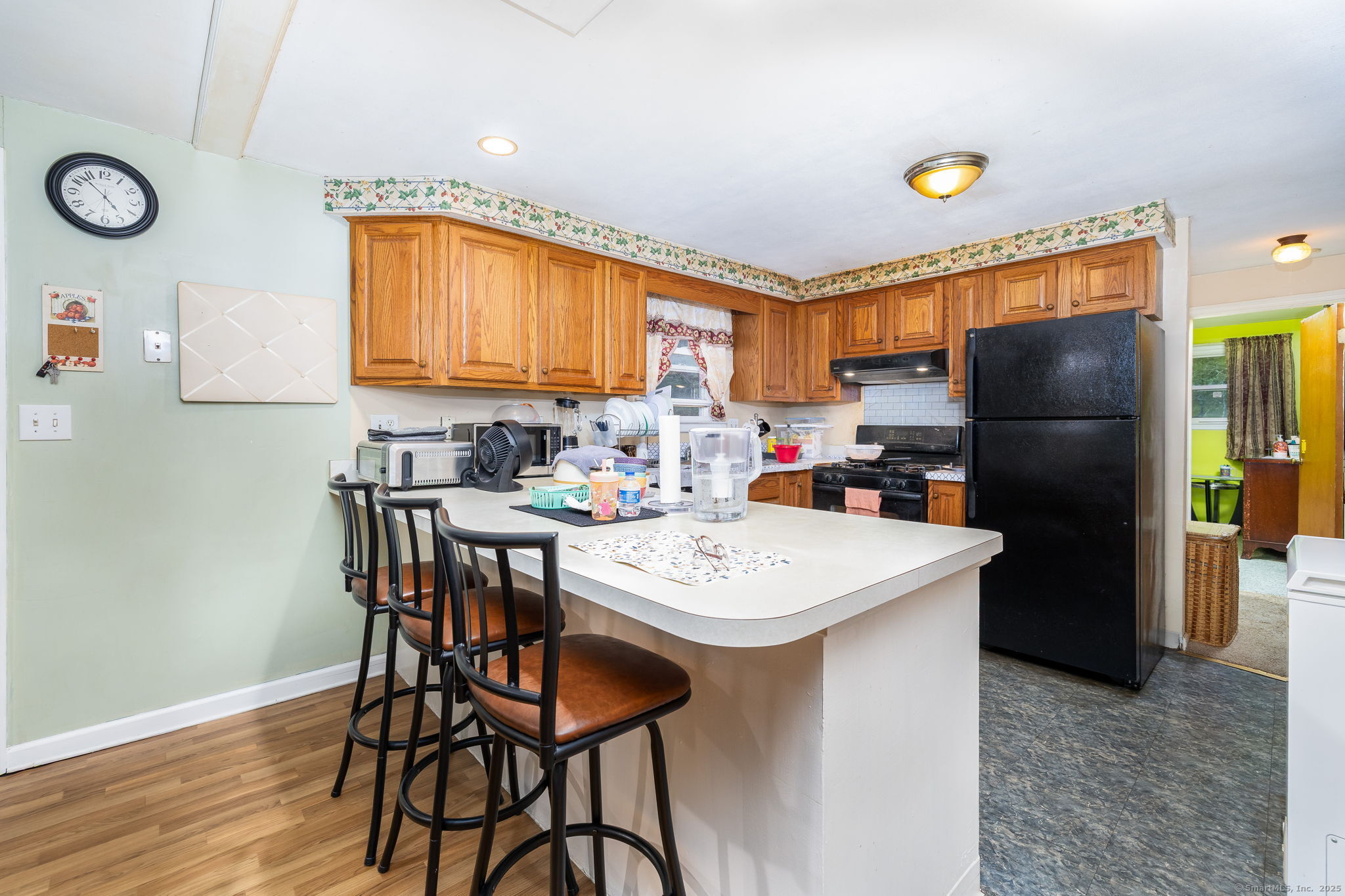 173 Timber Trail Wethersfield, CT 06109 - Photo 7 of 18 a kitchen with a refrigerator a stove a sink and a dining table with chairs