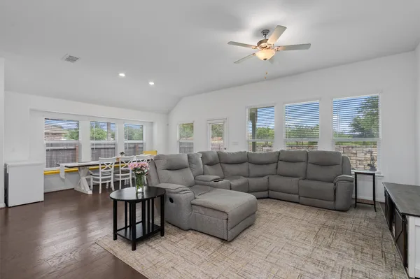a living room with furniture floor to ceiling window and wooden floor