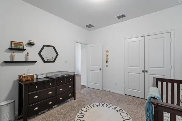 a bedroom with a dresser and a mirror