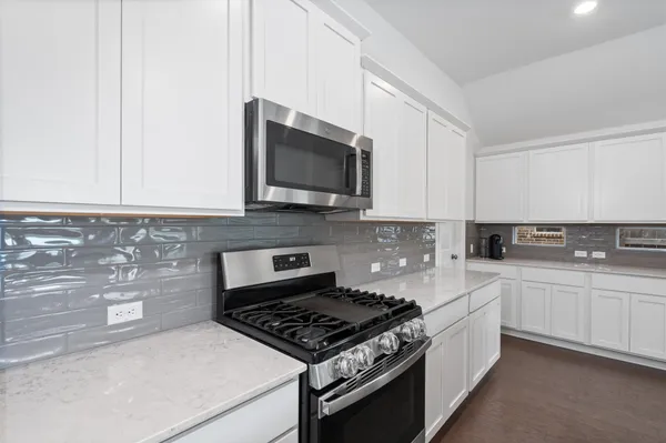 a kitchen with stainless steel appliances a sink a stove and microwave