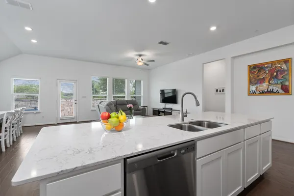 a kitchen with stainless steel appliances granite countertop a sink and white cabinets