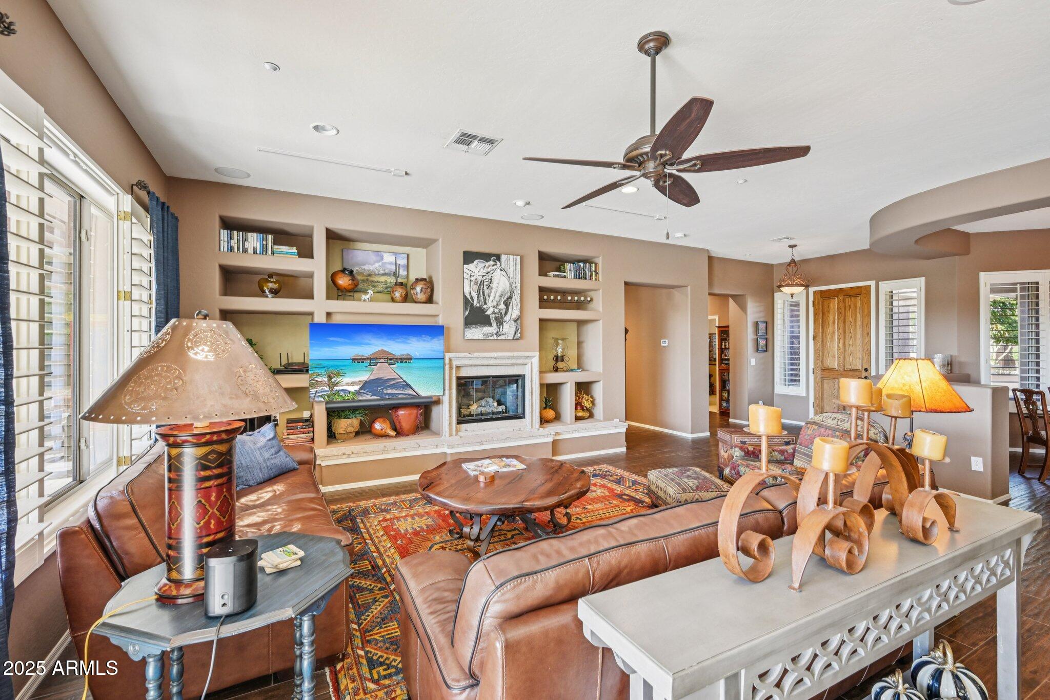 41725 North Golf Crest Road Anthem, AZ 85086 - Photo 16 of 60 a living room with furniture a ceiling fan and a window