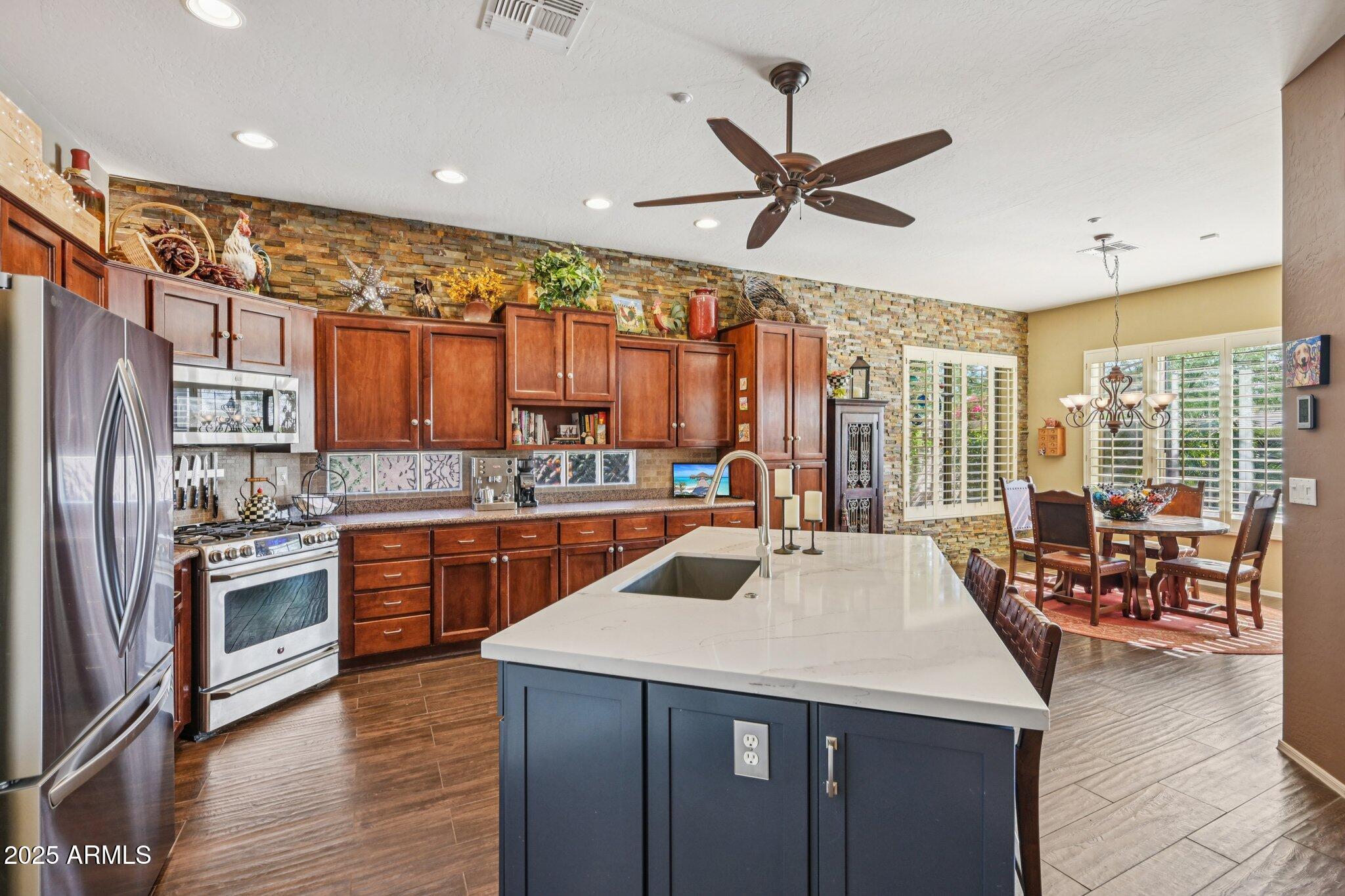 41725 North Golf Crest Road Anthem, AZ 85086 - Photo 20 of 60 a kitchen with stainless steel appliances granite countertop a sink and a refrigerator