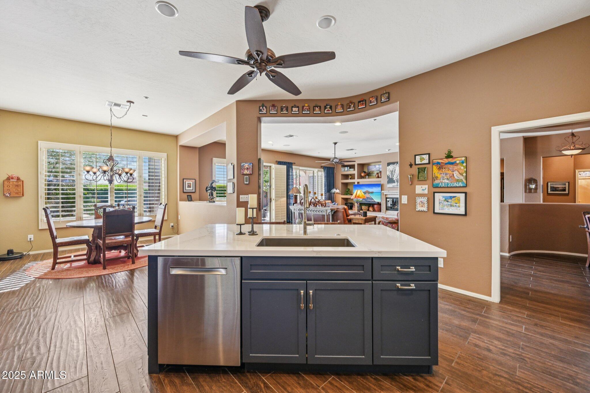 41725 North Golf Crest Road Anthem, AZ 85086 - Photo 23 of 60 a living room with granite countertop furniture a wooden floor to ceiling window and a flat screen tv
