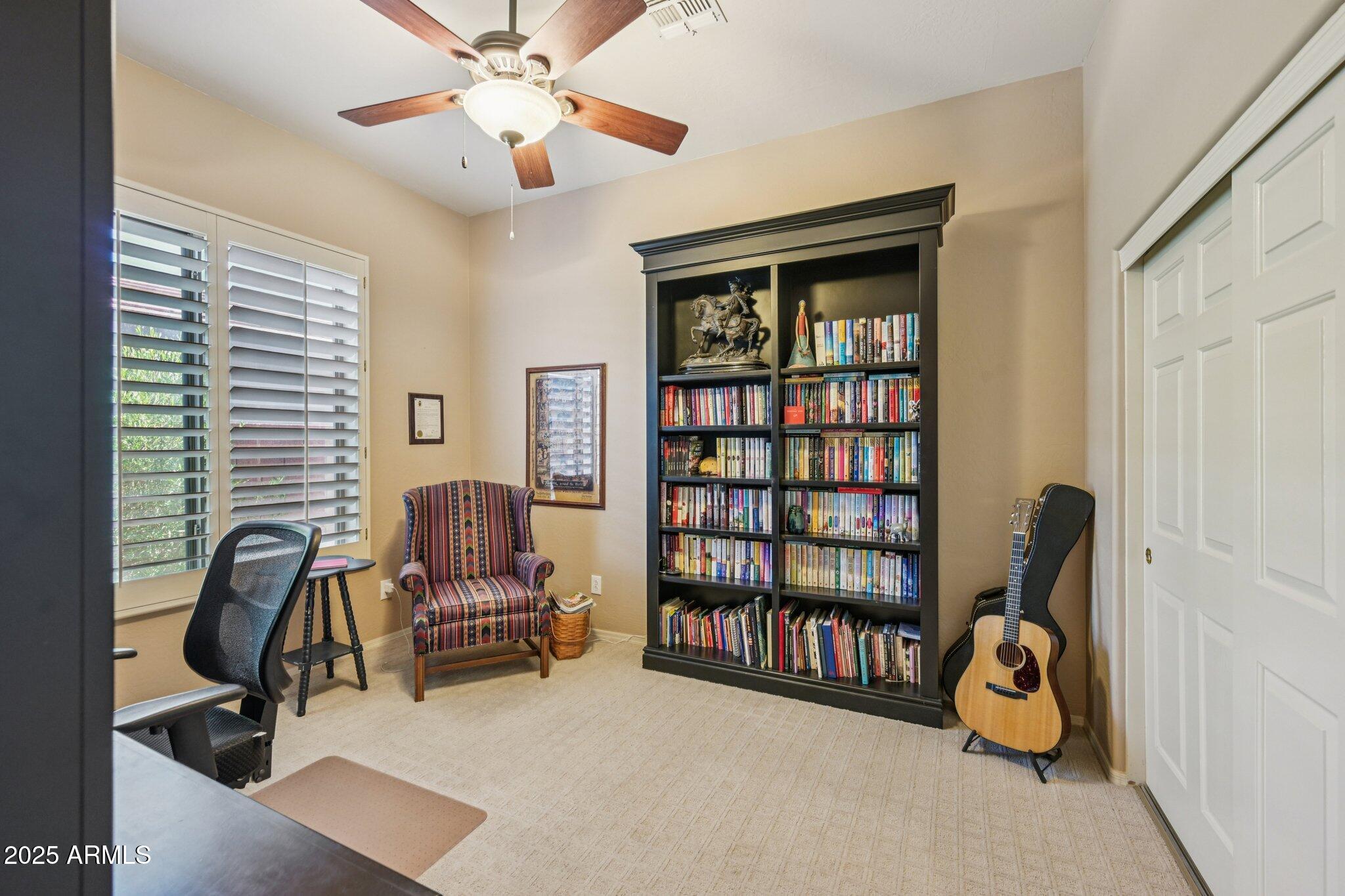41725 North Golf Crest Road Anthem, AZ 85086 - Photo 31 of 60 a living room with furniture and a book shelf