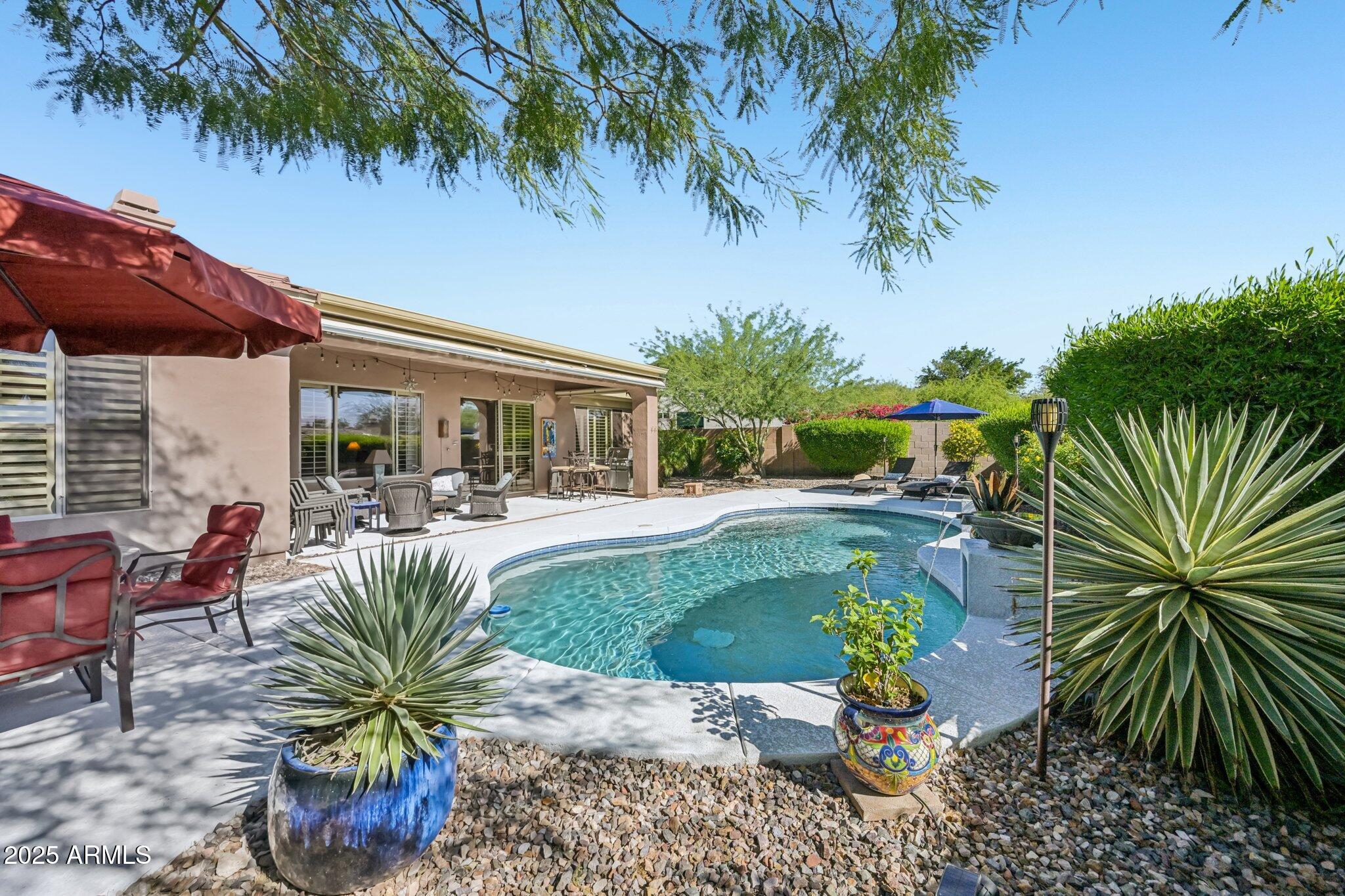41725 North Golf Crest Road Anthem, AZ 85086 - Photo 5 of 60 a view of a swimming pool with a patio and plants