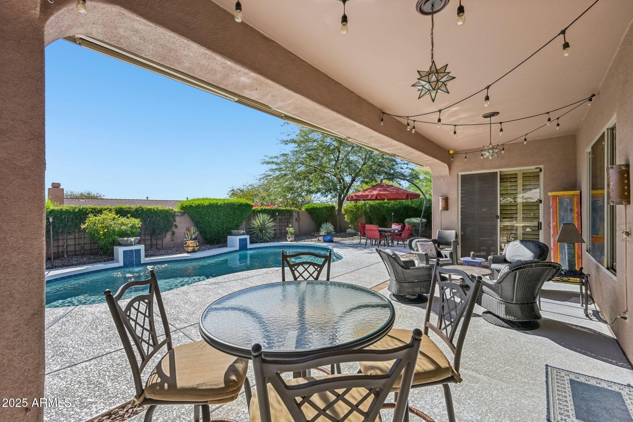 41725 North Golf Crest Road Anthem, AZ 85086 - Photo 6 of 60 a view of a patio with a dining table and chairs