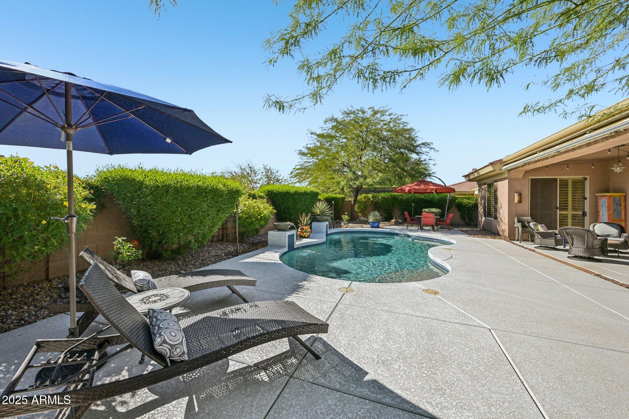 41725 North Golf Crest Road Anthem, AZ 85086 - Photo 8 of 60 a view of a patio with table and chairs under an umbrella
