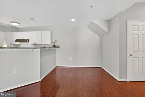 a view of a kitchen with wooden floor and electronic appliances