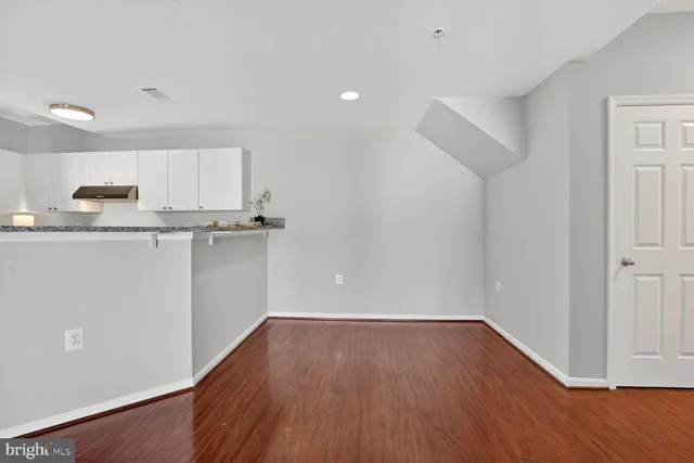 a view of a kitchen with wooden floor and electronic appliances