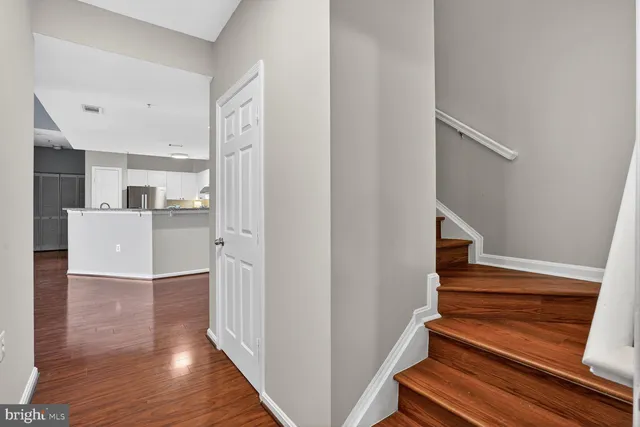 a view of a hallway with wooden floor and staircase