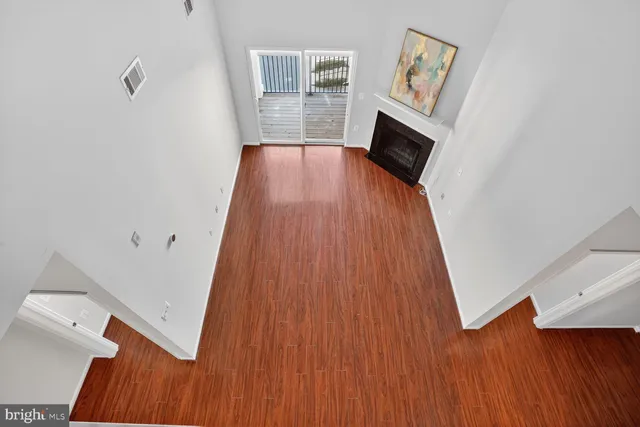 a view of a livingroom with wooden floor and a fireplace