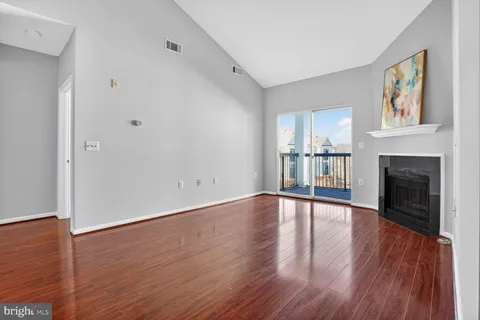 a view of empty room with wooden floor and fireplace