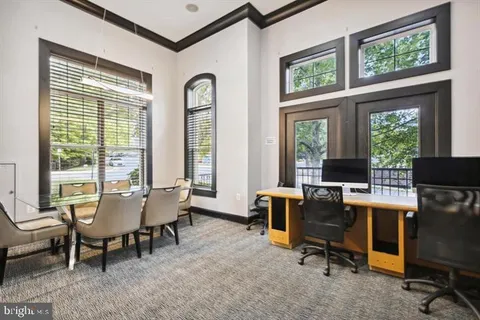 a view of a livingroom with workspace and windows