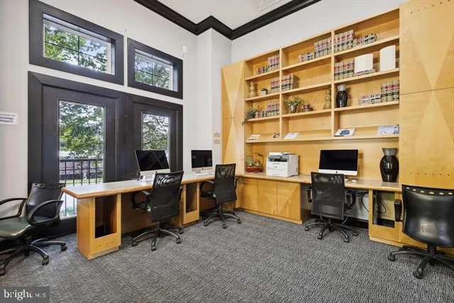a view of a workspace with furniture and a window