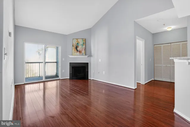 a view of empty room with wooden floor and fireplace