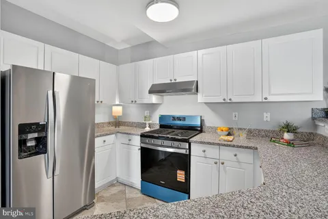 a kitchen with a white stove and white cabinets