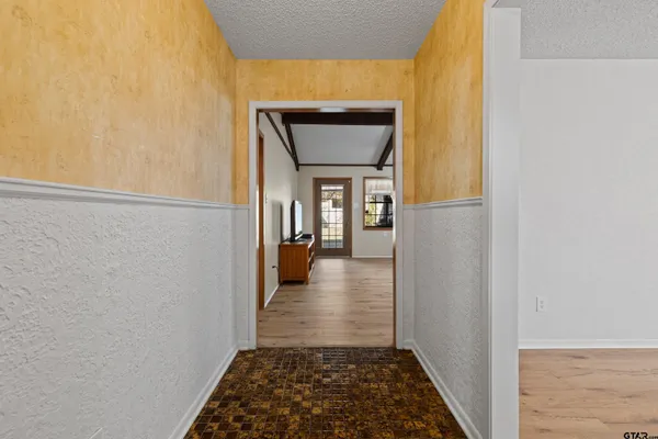 a view of a hallway with wooden floor and a dining room