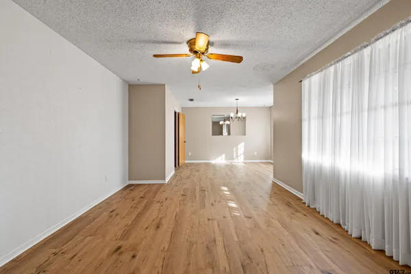 a view of empty room with wooden floor