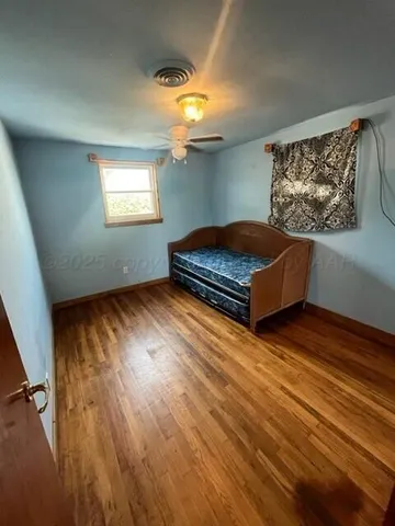a bedroom with a bed and wooden floor