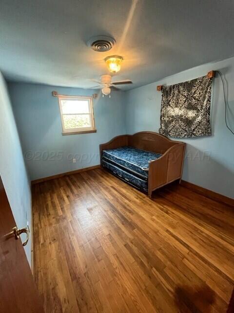 819 Ave N Sunray, TX 79086 - Photo 15 of 24 a bedroom with a bed and wooden floor