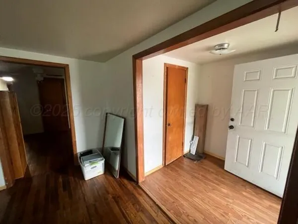 a view of a hallway with wooden floor and staircase