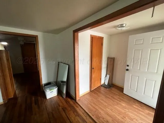 a view of a hallway with wooden floor and staircase