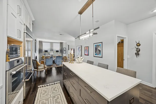 a large living room with stainless steel appliances furniture stove and a kitchen view