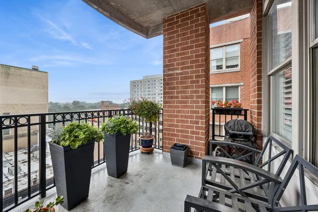 a view of a balcony with chairs and a potted plant