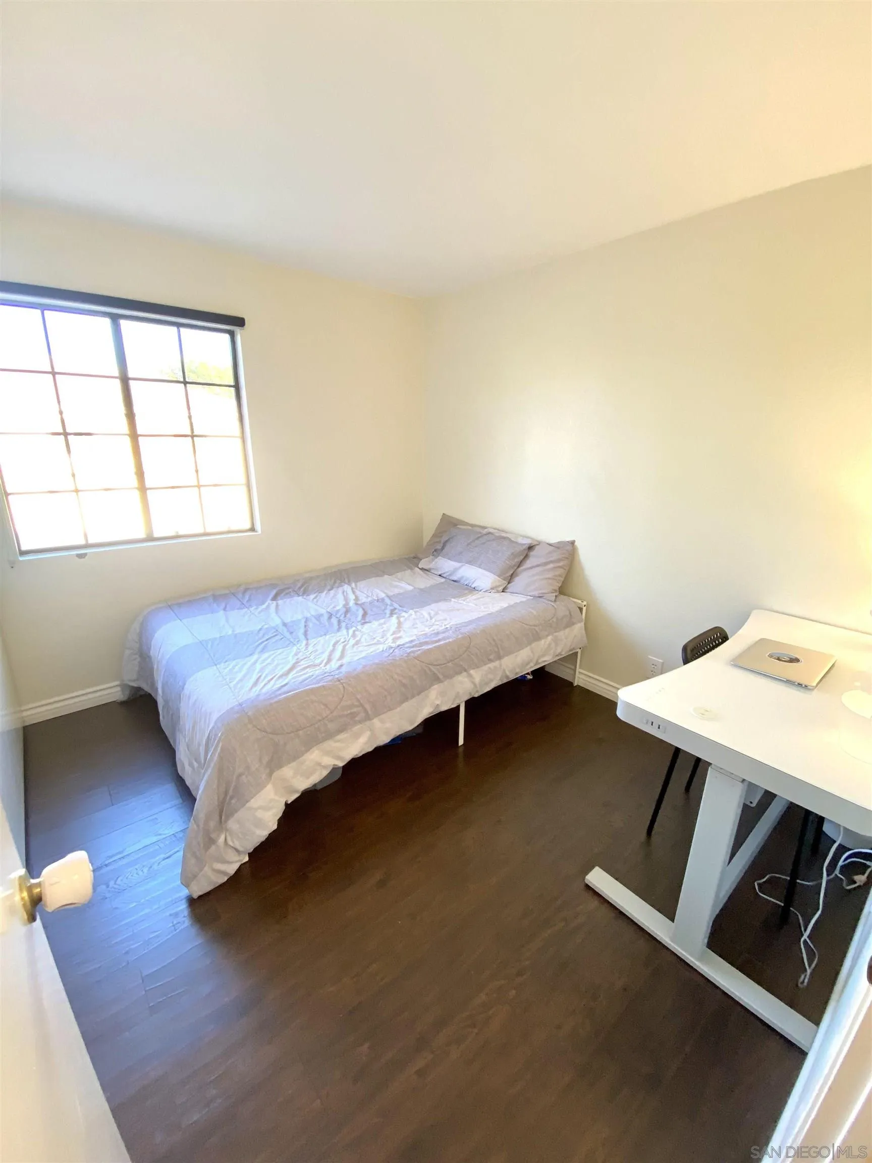 8834 Tamberly Lane, Unit D Santee, CA 92071 - Photo 12 of 28 a bed sitting in a bedroom next to a window