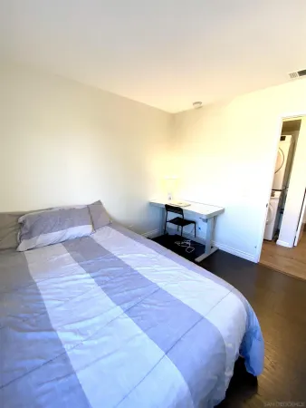 a bedroom with a bed and wooden floor