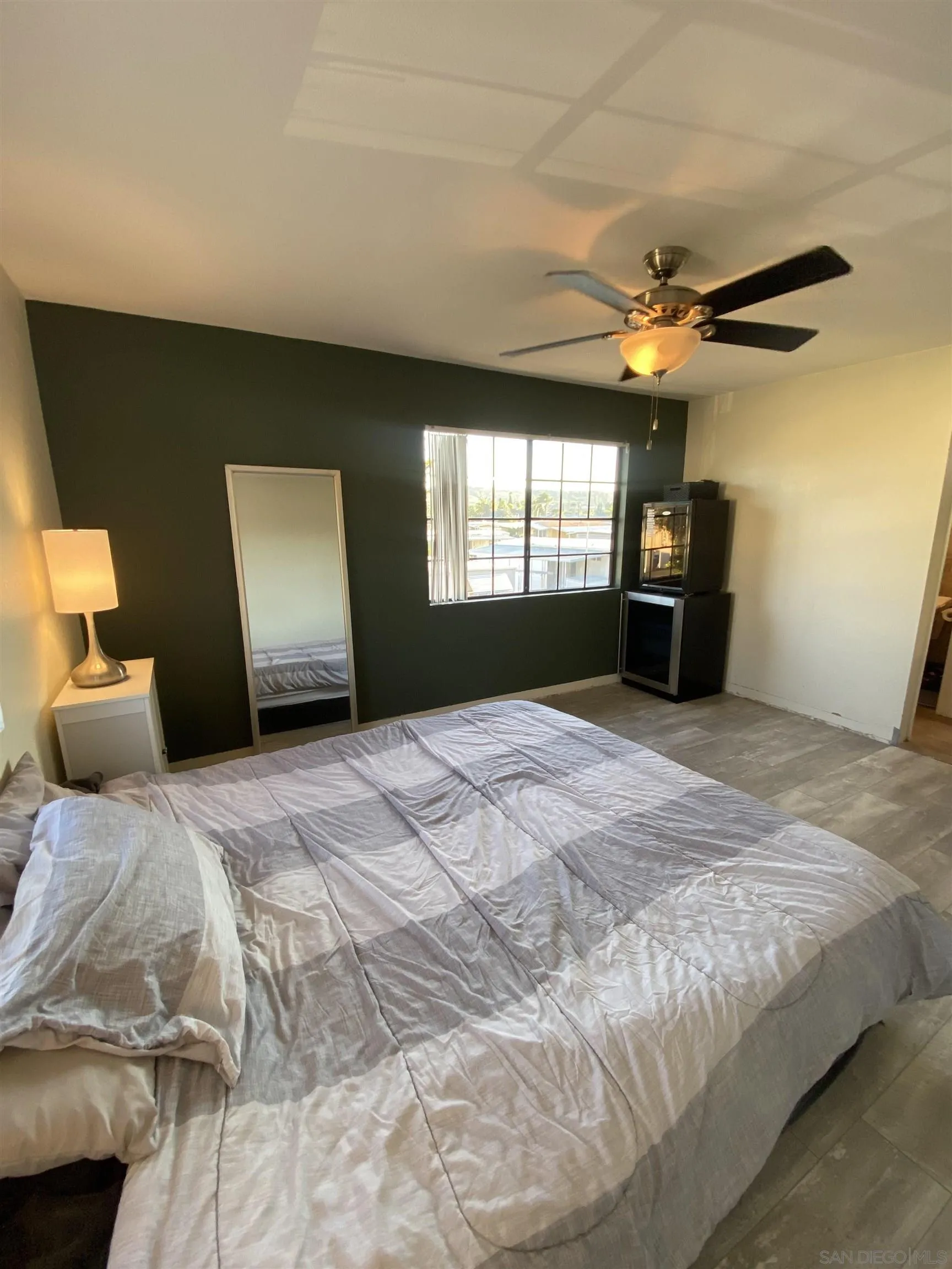 8834 Tamberly Lane, Unit D Santee, CA 92071 - Photo 16 of 28 a bedroom with a large bed and a chandelier