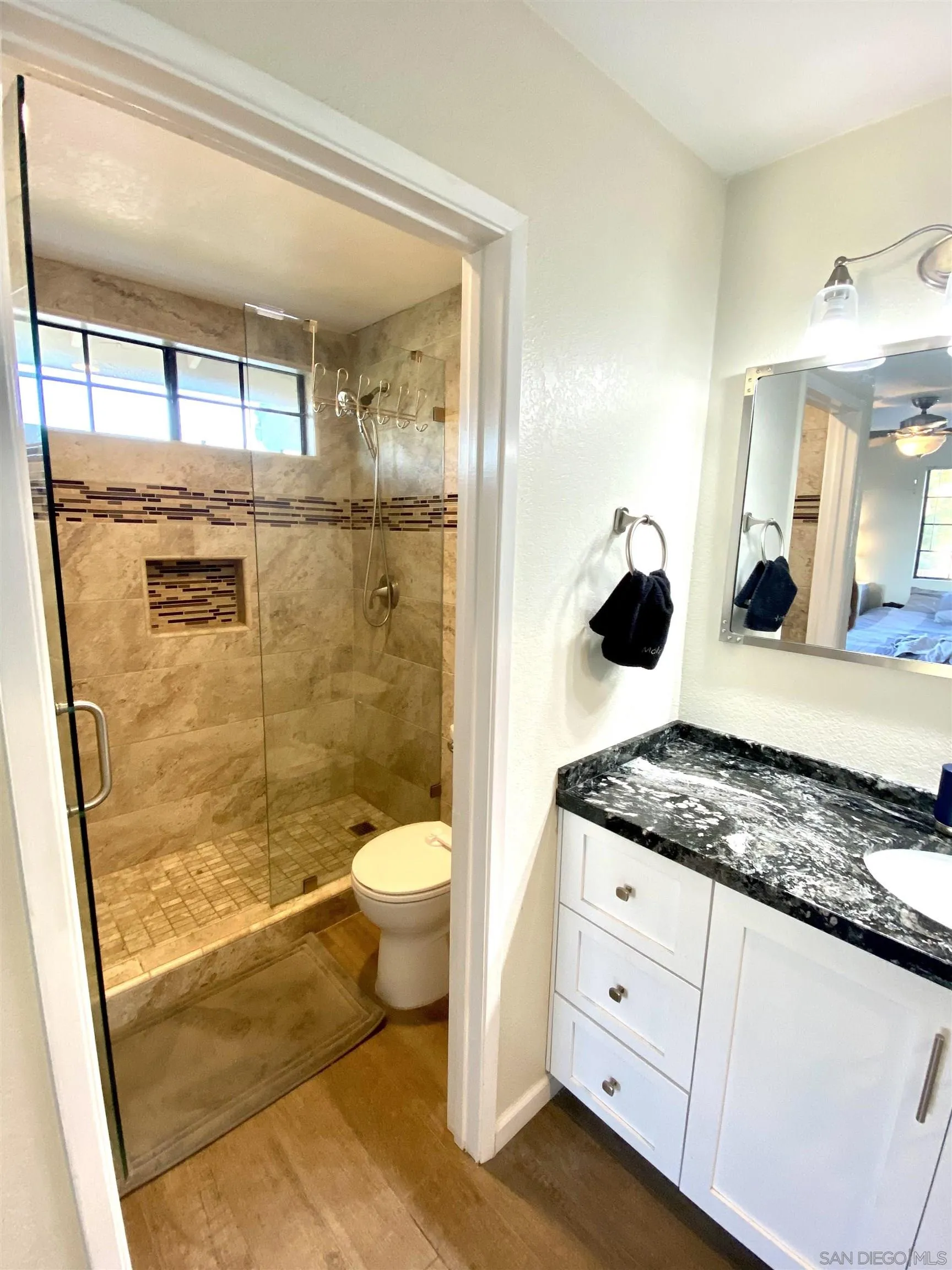 8834 Tamberly Lane, Unit D Santee, CA 92071 - Photo 17 of 28 a bathroom with a granite countertop sink mirror vanity and toilet
