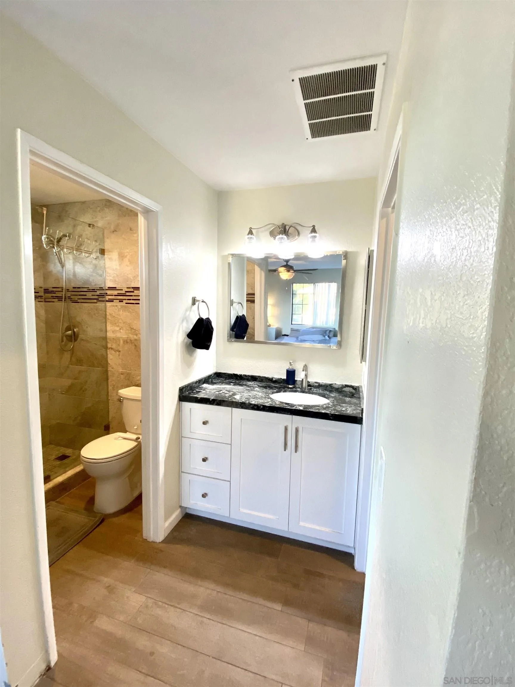 8834 Tamberly Lane, Unit D Santee, CA 92071 - Photo 22 of 28 a bathroom with a sink a toilet and a mirror