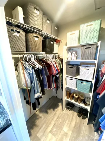 a view of walk in closet with clothes and shoes