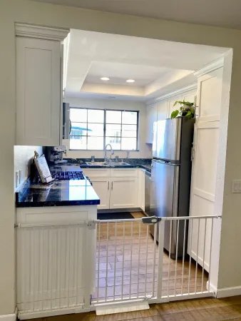 a kitchen with stainless steel appliances granite countertop a refrigerator sink and wooden cabinets
