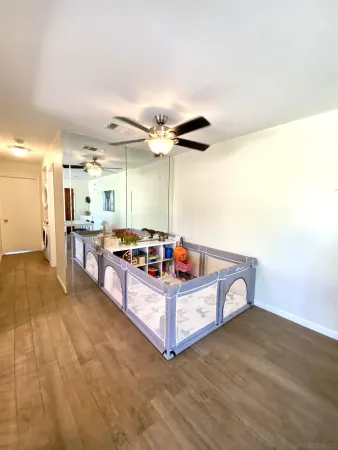 a living room with stainless steel appliances kitchen island granite countertop a sink cabinets and wooden floor