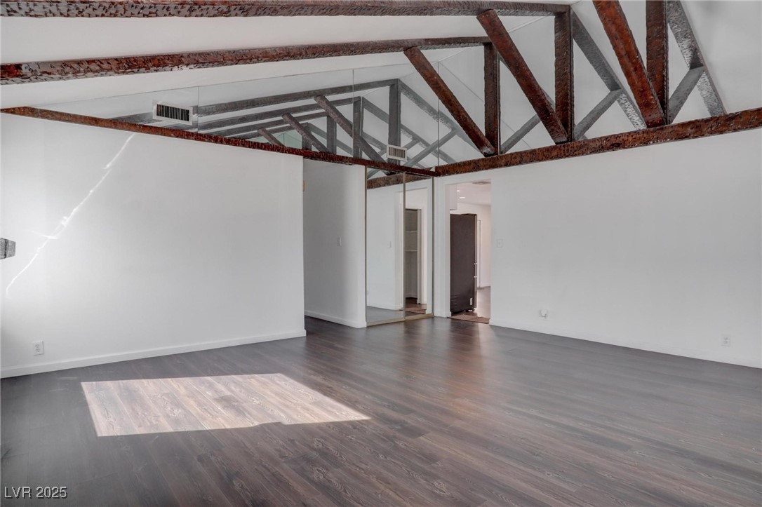 4775 Monaco Road Las Vegas, NV 89121 - Photo 5 of 31 Unfurnished room featuring dark wood-type flooring, high vaulted ceiling, and beamed ceiling
