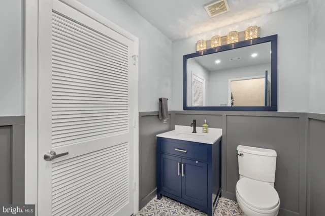 a bathroom with a toilet a sink a mirror and vanity