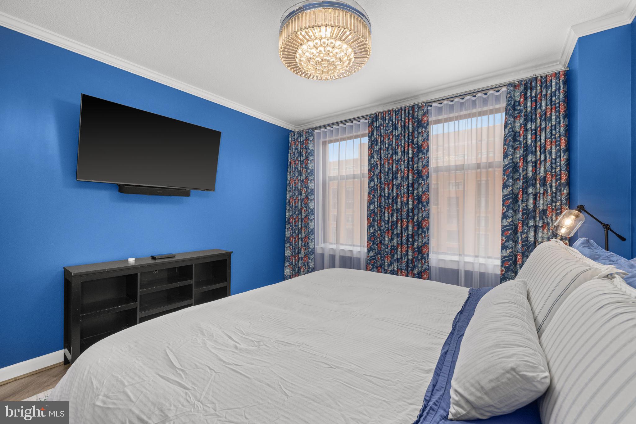 400 Massachusetts Avenue Northwest, Unit 1011 Washington, DC 20001 - Photo 14 of 31 a bedroom with a bed and a television