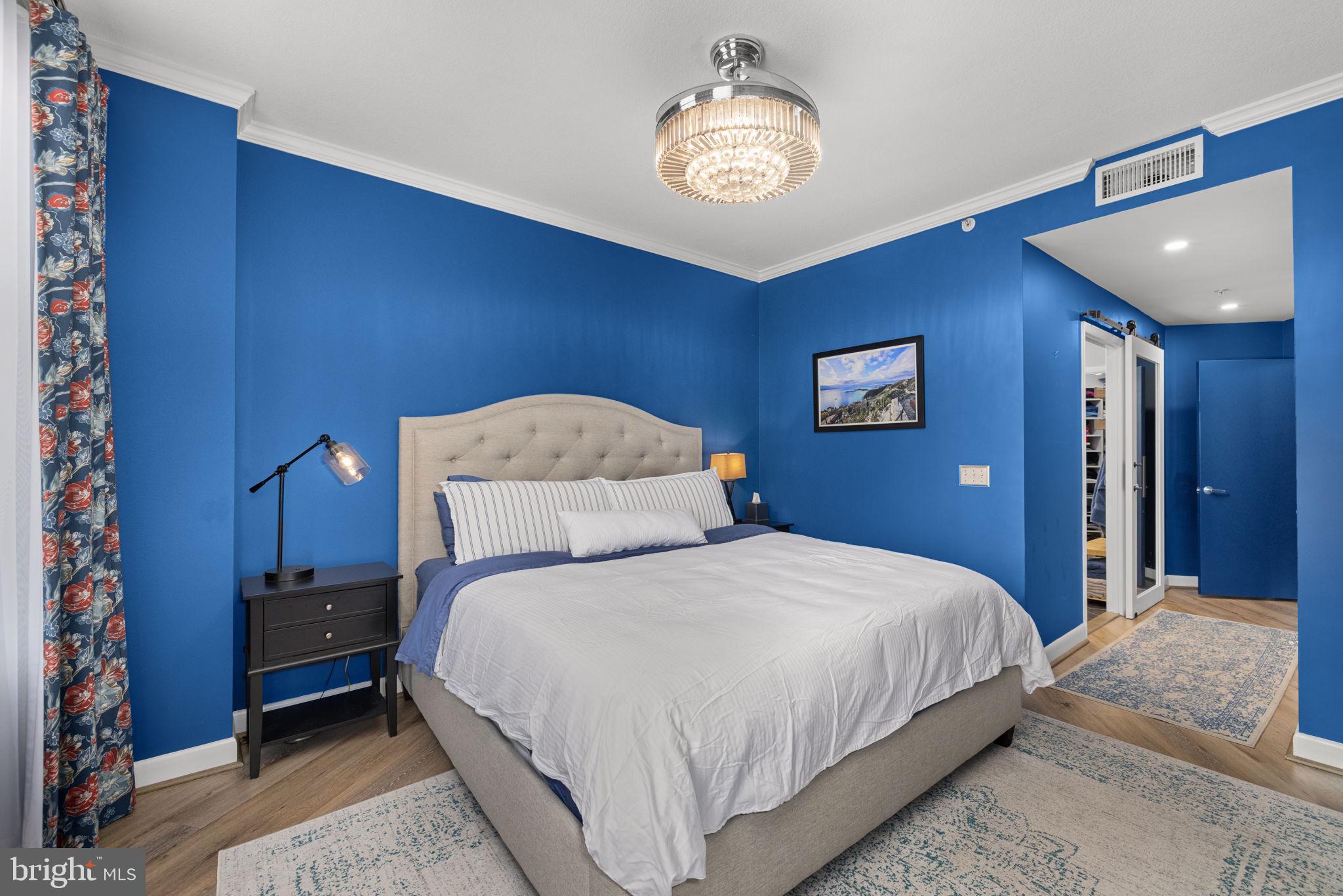 400 Massachusetts Avenue Northwest, Unit 1011 Washington, DC 20001 - Photo 15 of 31 a bedroom with a bed and a chandelier