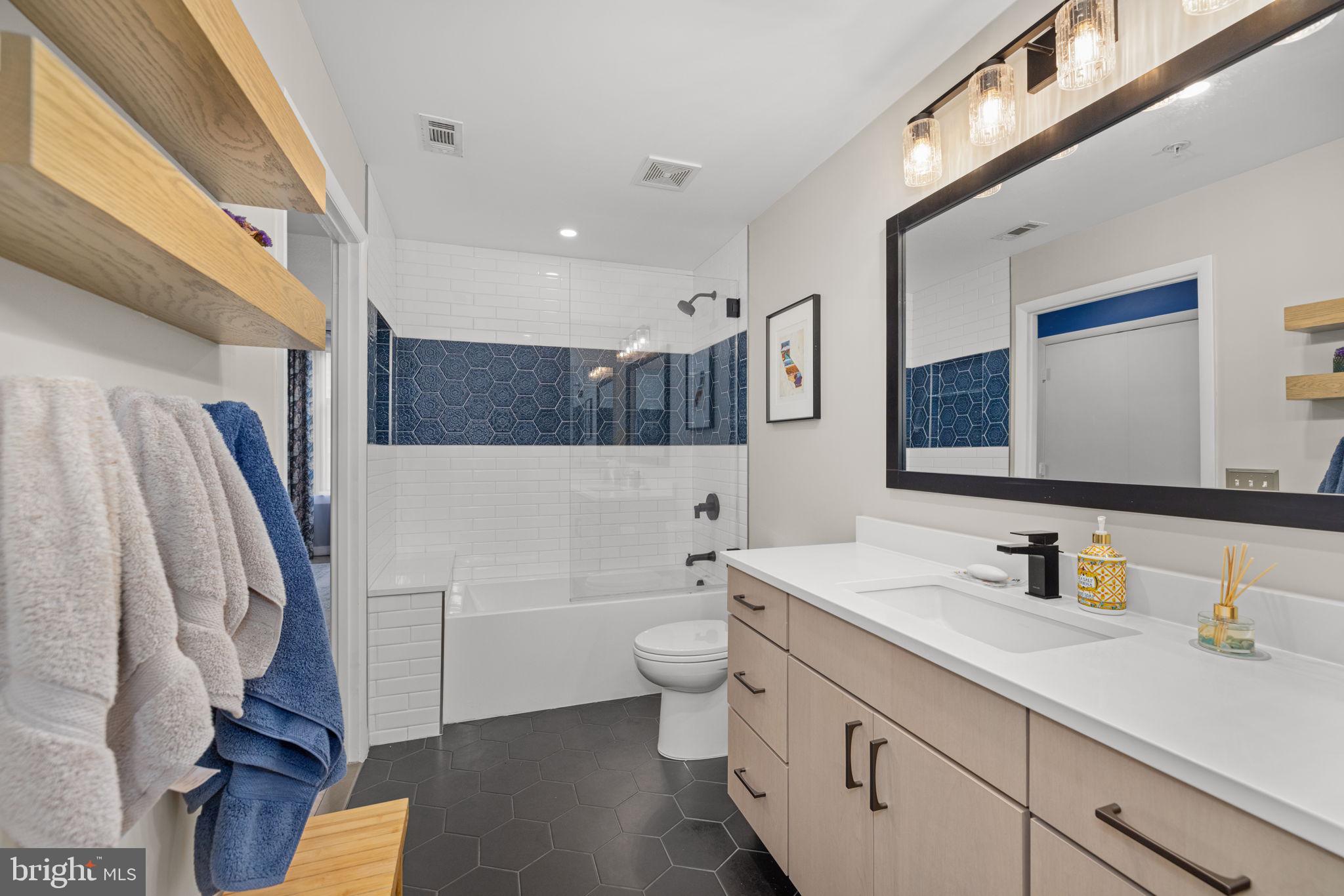 400 Massachusetts Avenue Northwest, Unit 1011 Washington, DC 20001 - Photo 17 of 31 a bathroom with a sink a toilet and a large mirror