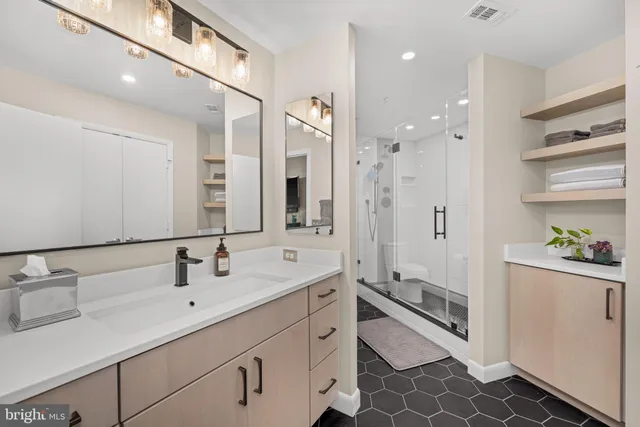 a bathroom with a granite countertop toilet a sink and a shower