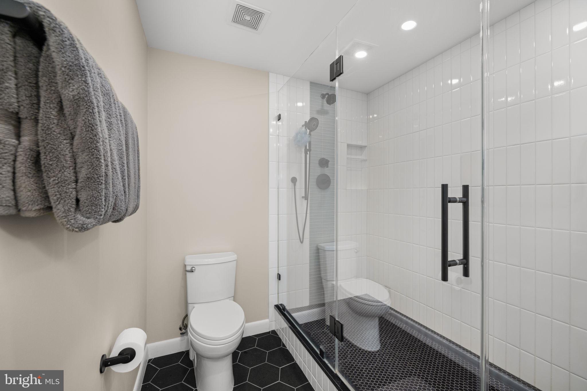 400 Massachusetts Avenue Northwest, Unit 1011 Washington, DC 20001 - Photo 20 of 31 a bathroom with a granite countertop toilet a sink and a shower