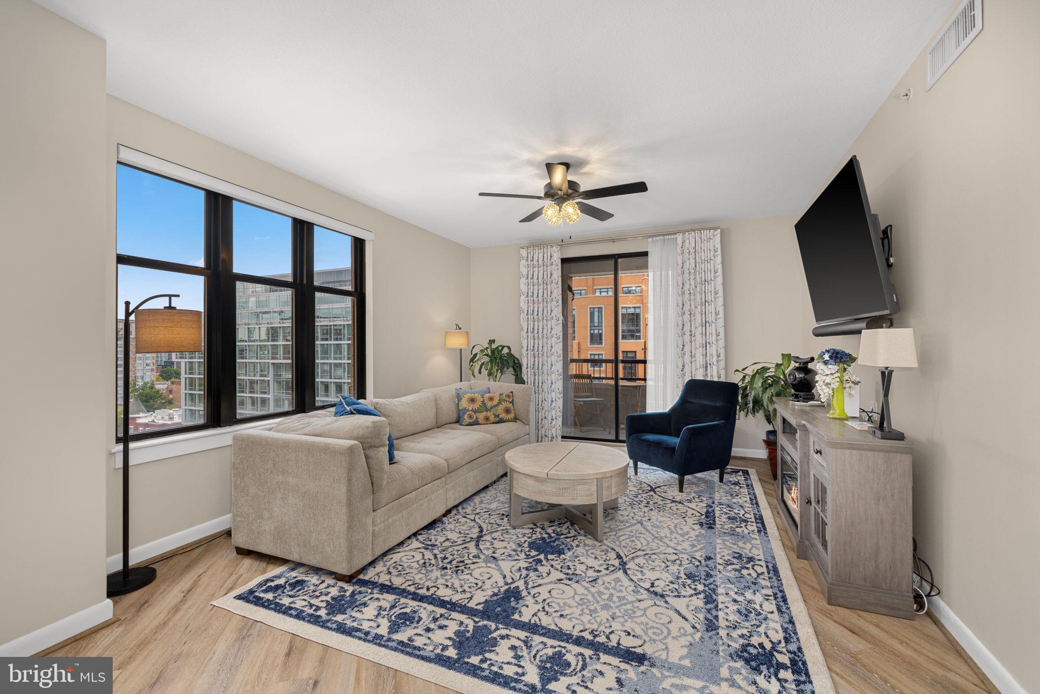 400 Massachusetts Avenue Northwest, Unit 1011 Washington, DC 20001 - Photo 2 of 31 a living room with furniture a flat screen tv and a floor to ceiling window
